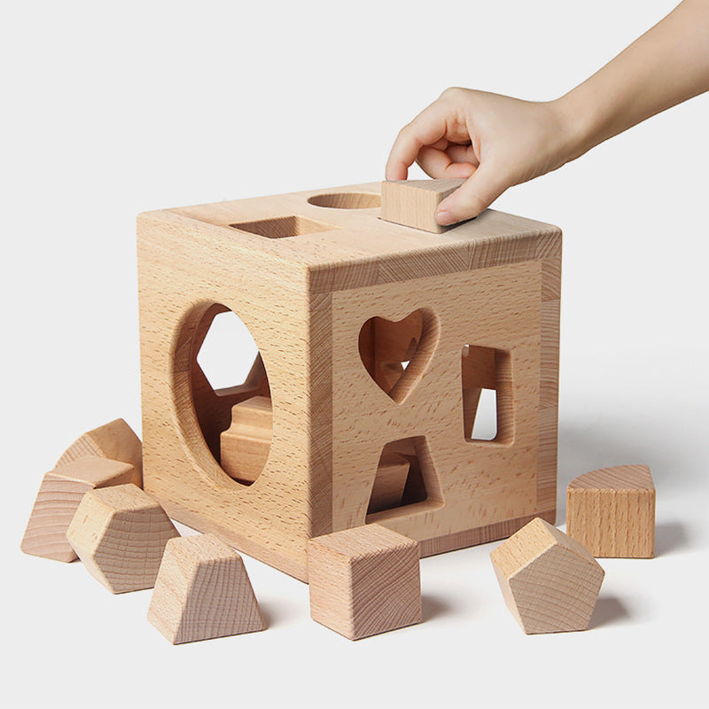 18-month-old child safely touching unfinished beechwood shape sorter with smooth edges, experiencing natural sensory play