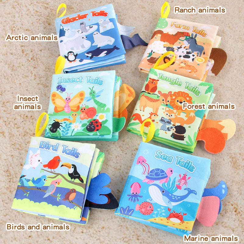 Open Busy Book showing interactive pages: penguin (Arctic), cow (farm), butterfly (insects), zebra (wild), parrot (birds), and whale (sea). Hand-drawn baby activity toy.