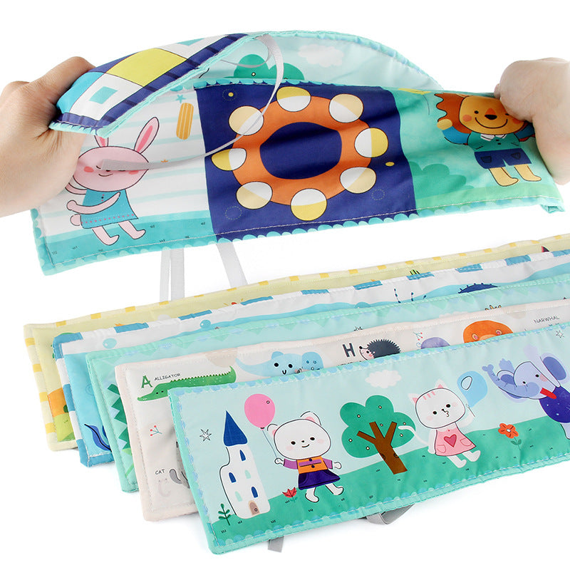 Newborn baby looking at a double-sided contrast book attached to the crib for visual development